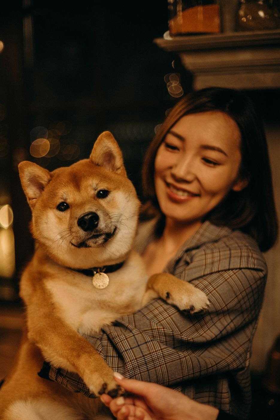 A pet owner smiling with her happy dog at home